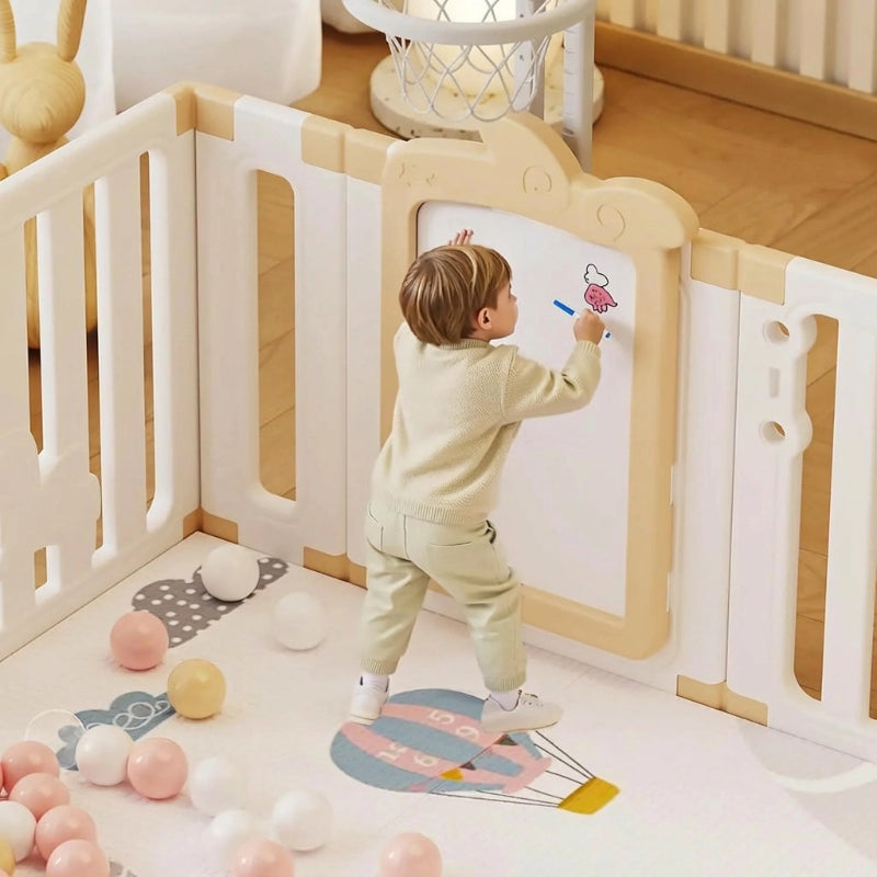 Un enfant dessine sur un tableau du Parc pour bebe geant avec porte motif licorne