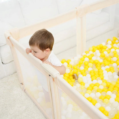 un bébé dans le Parc bebe pliant en tissu beige