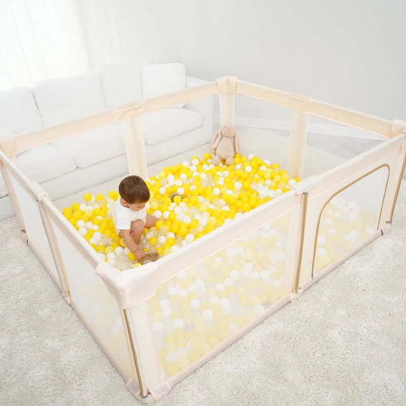 un bébé jouant dans le Parc bebe pliant en tissu beige